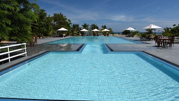 Una piscina al aire libre, tumbonas