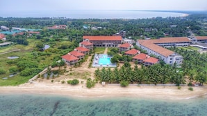 An aerial view of a resort with multiple buildings, a central pool, and a beach. - Passi Villas Passikudah (Pasikuda)