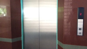 An elevator with a metallic interior, a digital display showing the number 2, and a control panel with an upward arrow. - C.S. Apartment Hat Yai (Hat Yai)
