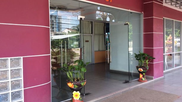 A building entrance with a glass door, number 87, and potted plants in front. - C.S. Apartment Hat Yai (Hat Yai)