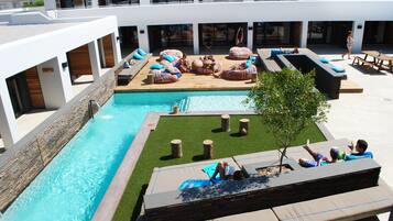 Relax by the pool surrounded by lush greenery and comfortable seating options.