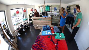 A room with a large window, a reception desk, and various sports equipment.