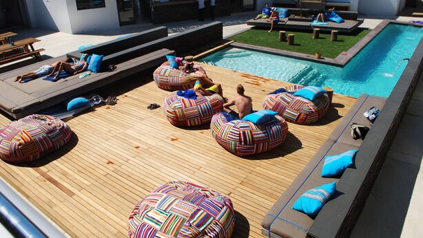 A rooftop pool area with lounge chairs and bean bags. - Windtown Lagoon Hotel (Langebaan)