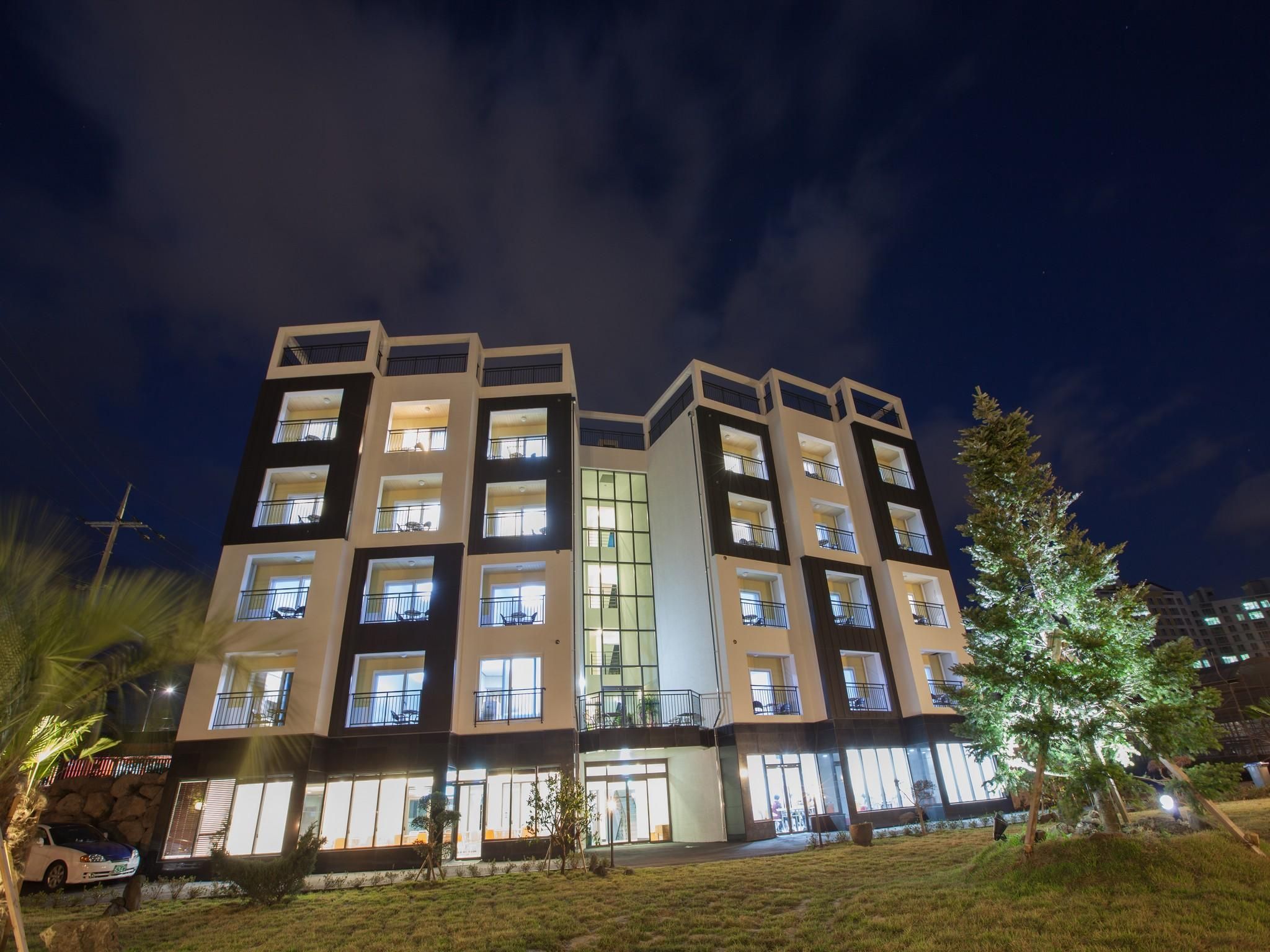 A multi-story hotel with a modern architectural design, featuring balconies and large windows.