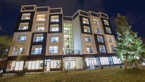 A multi-story hotel with balconies, large windows, and a well-lit facade at night. - Fellisia Hotel (Seogwipo)