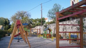 A playground with various play structures including a swing set and climbing frames. - Villa Romantza (Kefalonia)