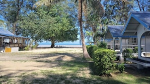 A beachfront property with a large tree, a covered porch, and a view of the sea. - PAN Beachfront Resort Krabi (Krabi)