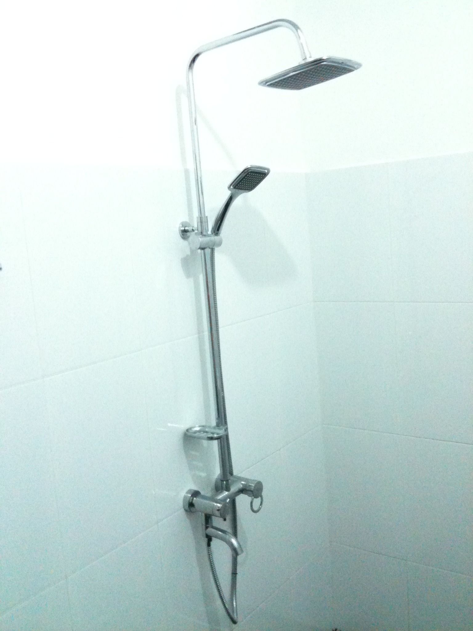 A shower with a handheld showerhead and a fixed overhead showerhead.