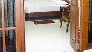 Une chambre à coucher avec un lit, une chaise et une porte en bois.