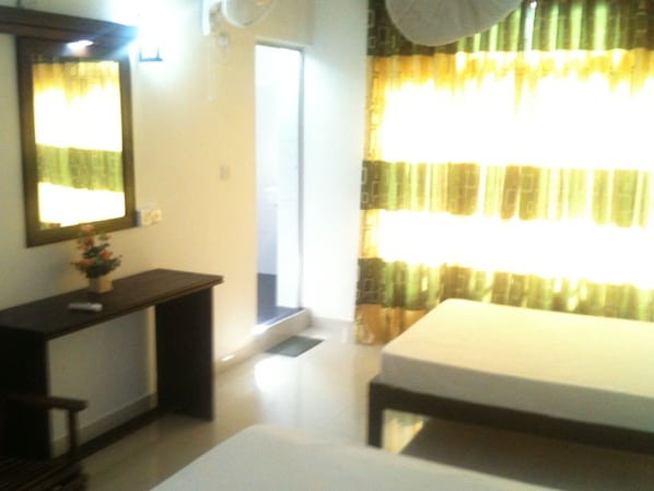 Quarto com cama, mesa de cabeceira, espelho e janela com cortinas.