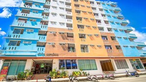 A multi-story hotel with balconies, a ground-level entrance, and several parked scooters. - W Apartment Hat Yai (Hat Yai)