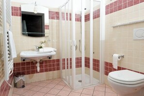 A bathroom with a glass shower enclosure, a sink, and a toilet. - Hotel Chopin (Genoa)