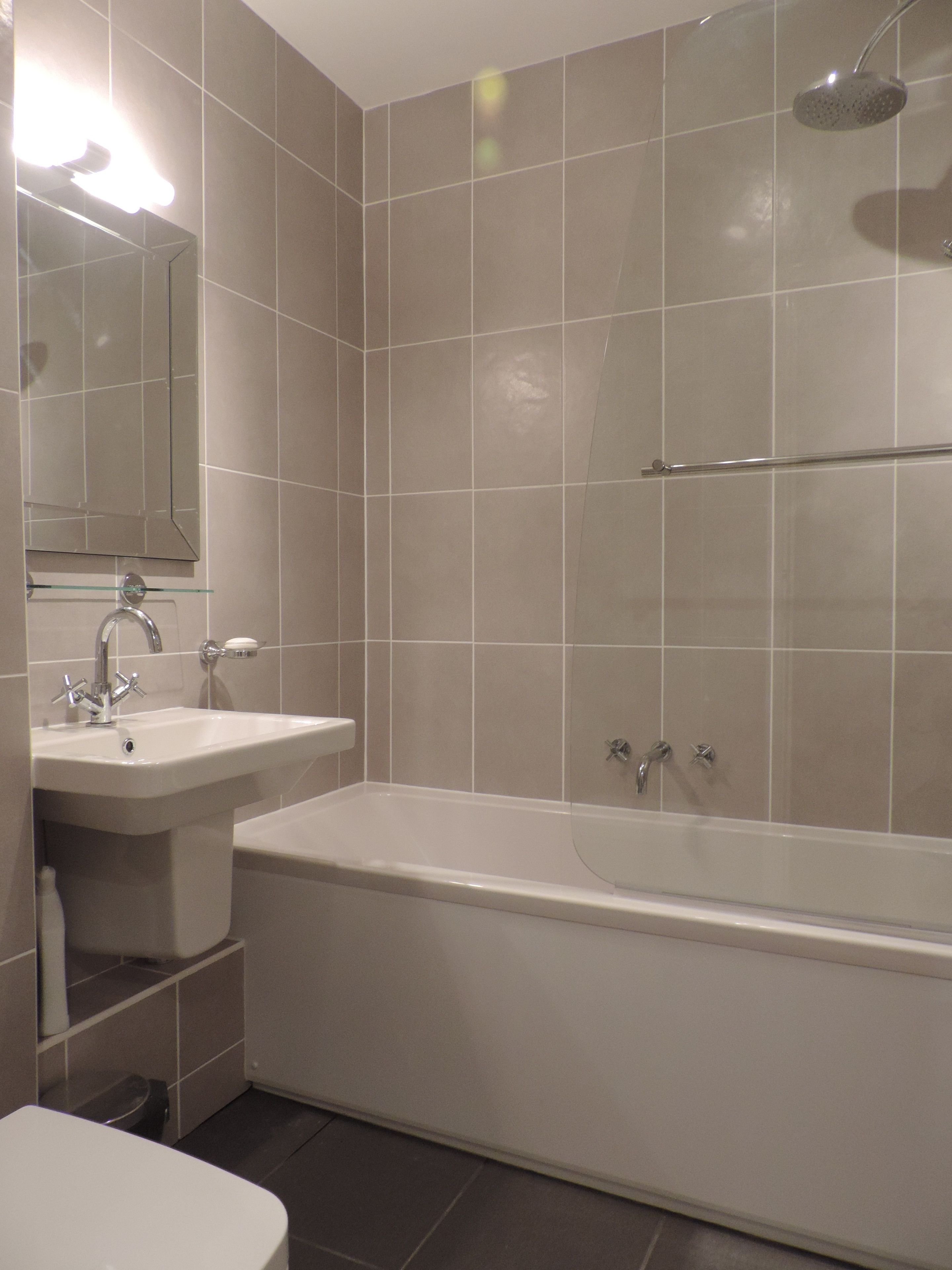 A modern bathroom with a bathtub, a sink, and a shower.