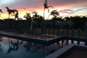 Piscina externa, guarda-sóis, espreguiçadeiras