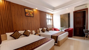Habitación de hotel con dos camas, paneles de madera en las paredes, un espejo grande y una silla roja.
