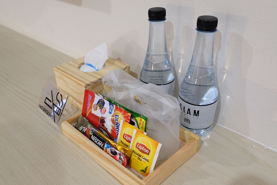 A tray with Lipton tea bags, Nescafe coffee, and a water bottle labeled "AM".
