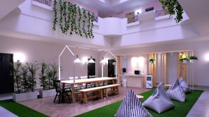 A modern interior with a dining area, kitchen, and seating with green artificial grass. - Siam Mansion Hat Yai (Hat Yai)