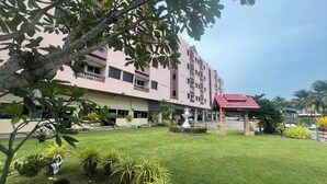 A hotel with a central courtyard, potted plants, and a fountain. - Muang Thong Family Suite Hat Yai (Hat Yai)