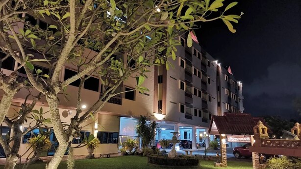 A hotel with multiple floors, a well-lit entrance, and a small outdoor area with a fountain and seating. - Muang Thong Family Suite Hat Yai (Hat Yai)