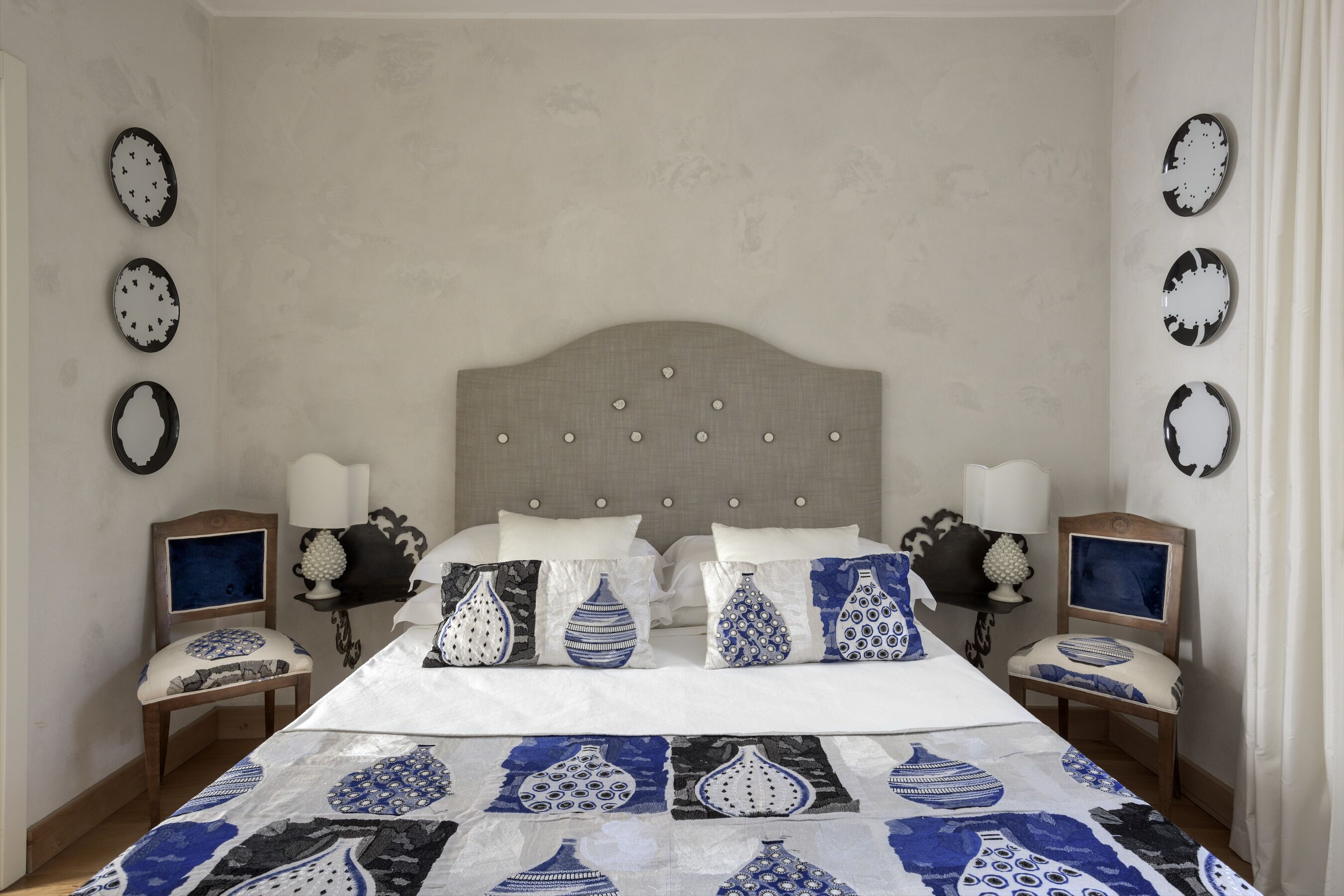 Un dormitorio con una cama grande, dos mesitas de noche y un cabecero.