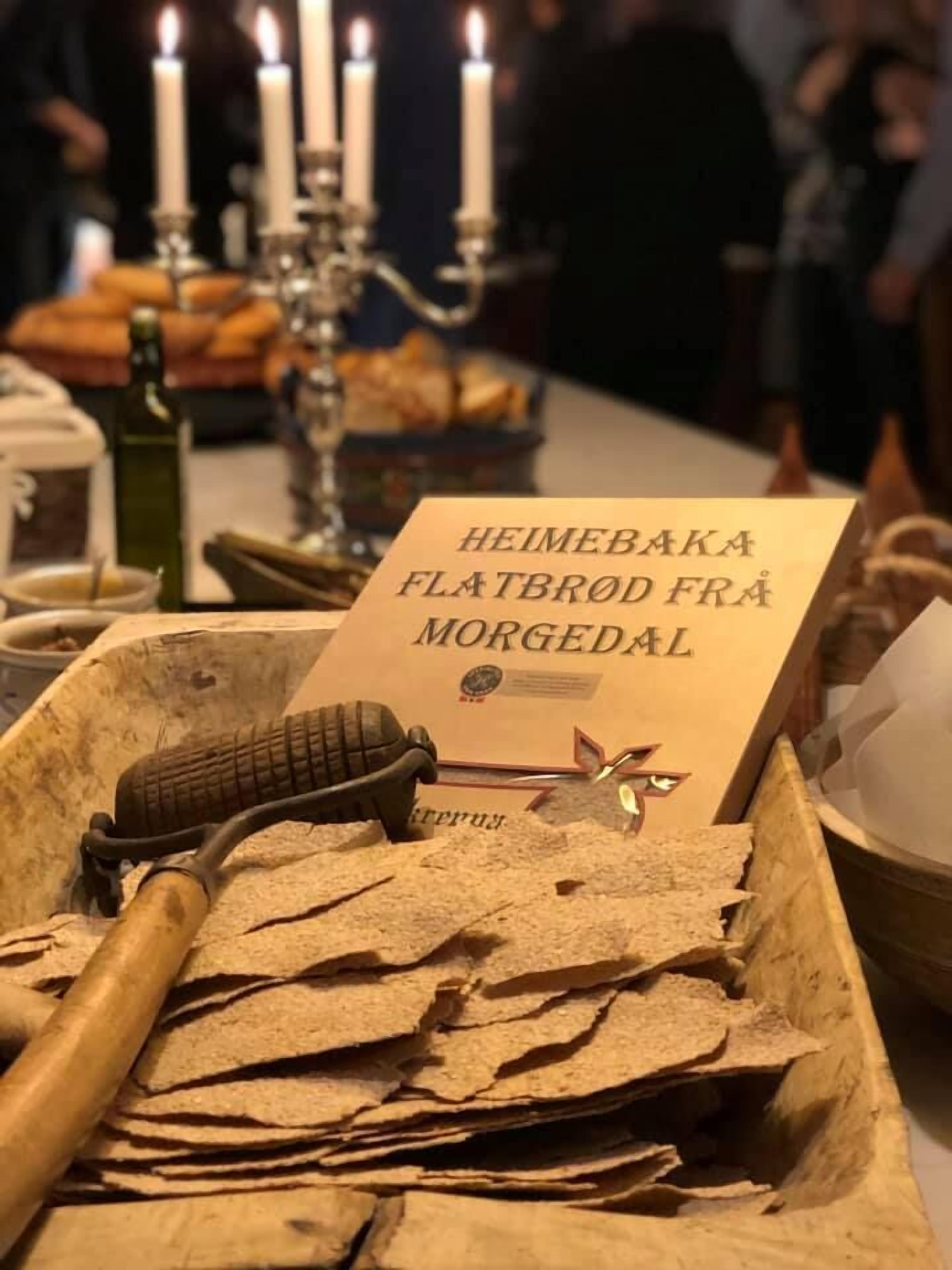 A flatbread tray with a sign reading "HEIMEBAKA FLATBROD FRA MORGEDAL" and a rolling pin.