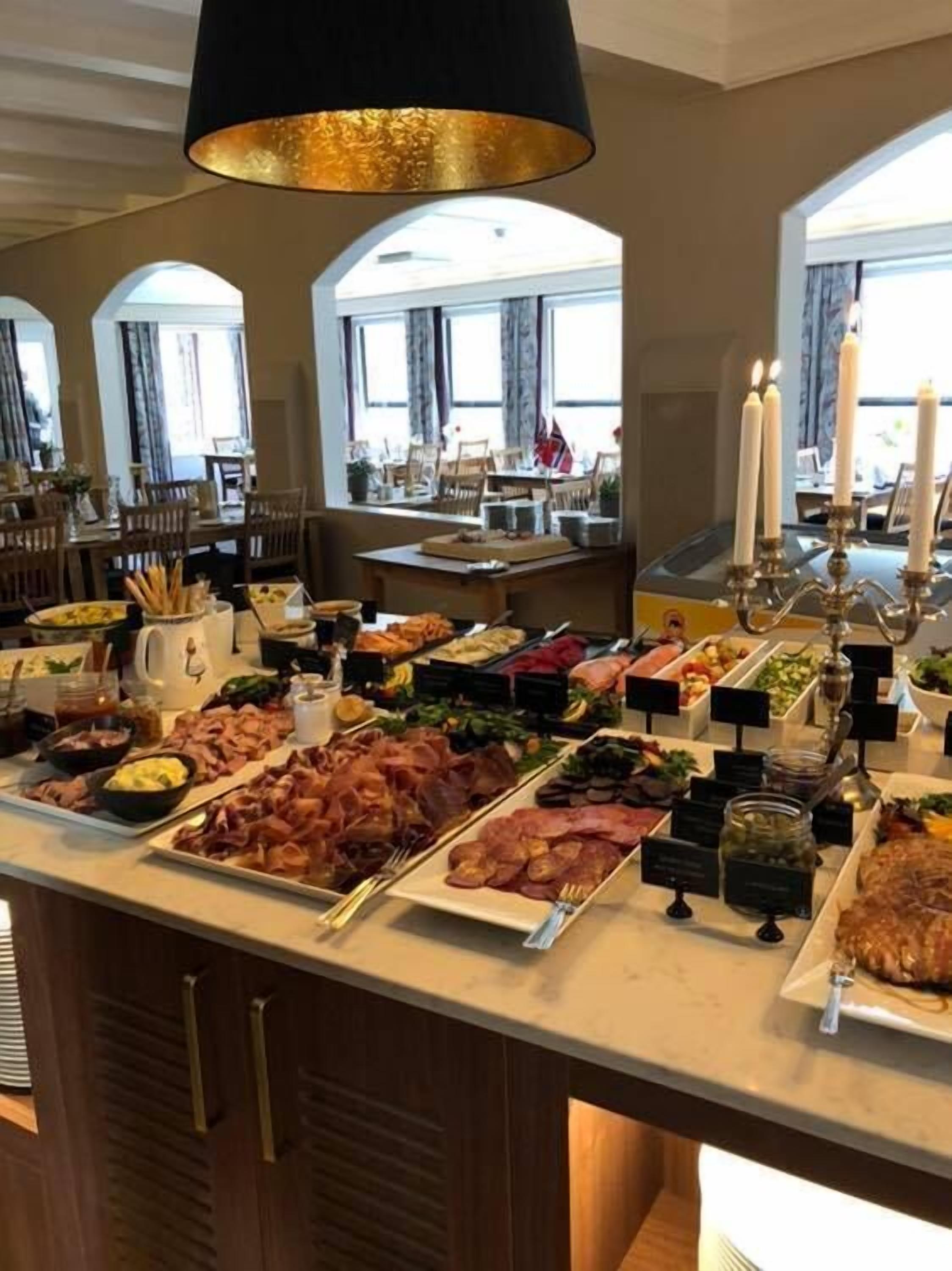 A buffet with various food items and a chandelier.