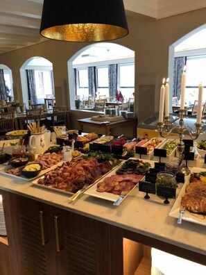 A buffet with various food items and a chandelier. - Morgedal Hotell - Unike Hoteller (Kviteseid)