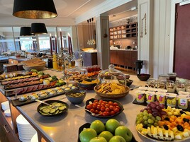 Una mesa de buffet con una variedad de alimentos, como frutas, quesos y embutidos.