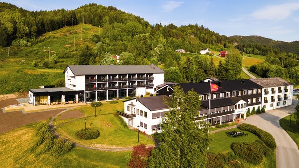 A hotel with multiple buildings, including a main structure with balconies and a smaller annex. - Morgedal Hotell - Unike Hoteller (Kviteseid)