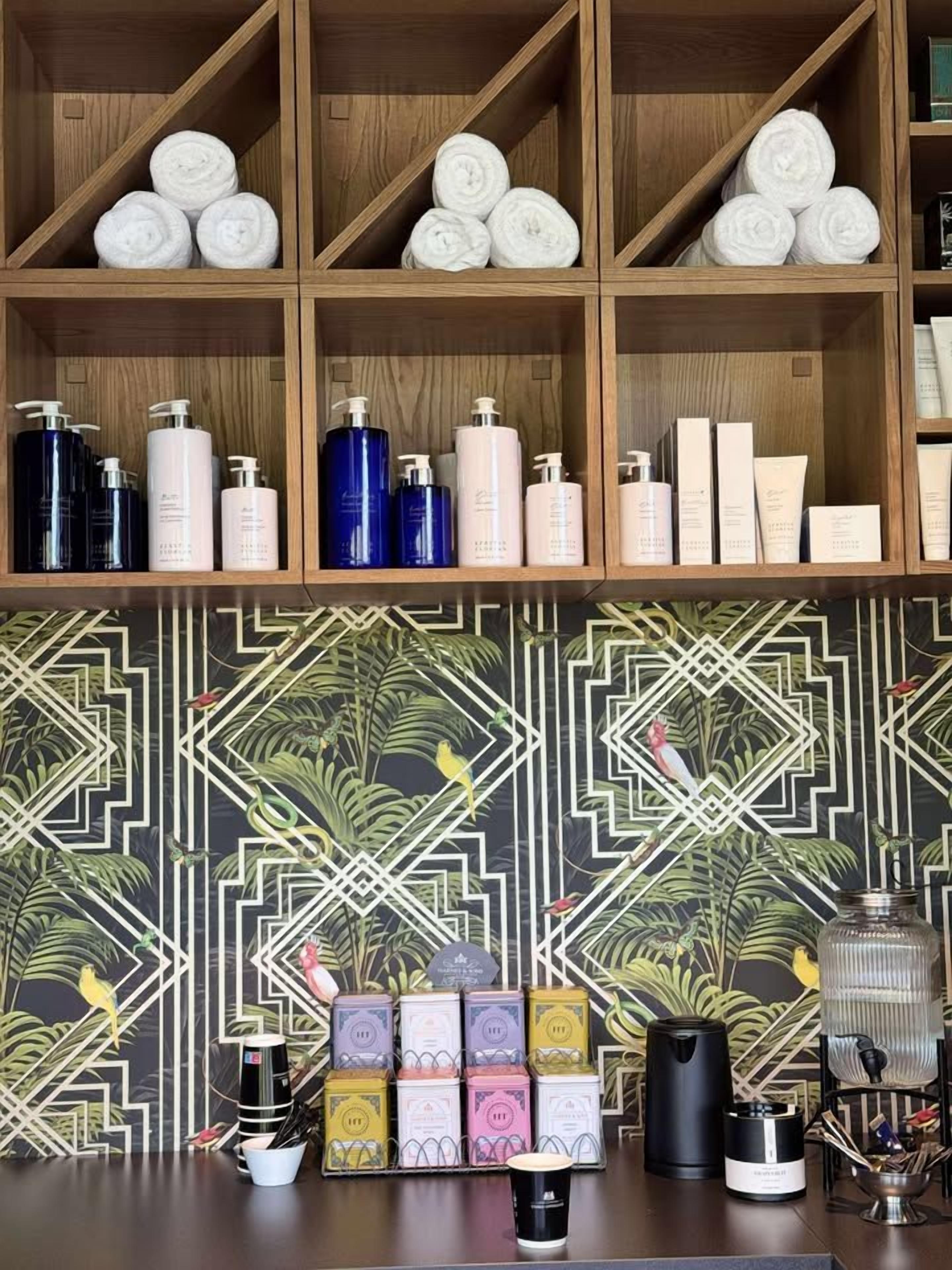 A shelf with neatly rolled towels and various toiletries.