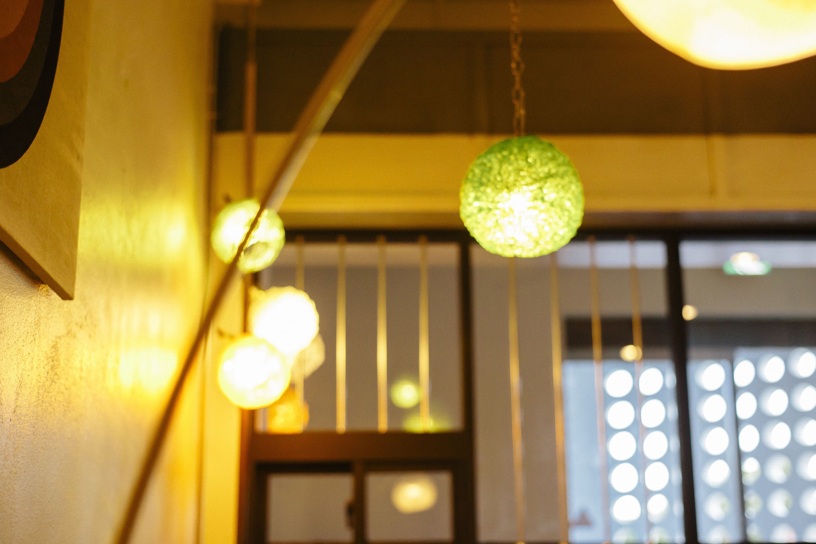 A room with hanging spherical lights and a wooden door with vertical slats.