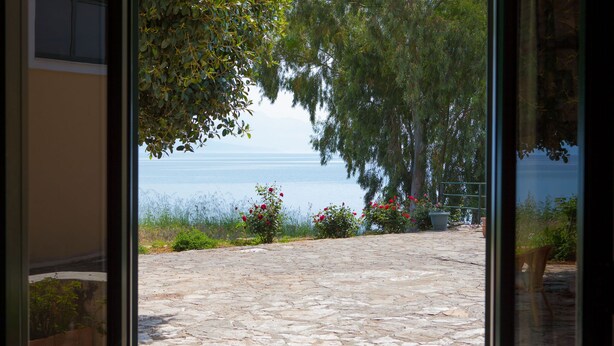 Un patio empedrado con vistas al mar y vegetación circundante.