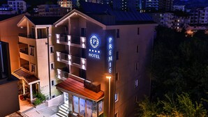 Un hotel con un letrero llamativo, varios balcones y una entrada bien iluminada.