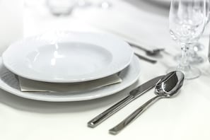 A neatly arranged dining table with a plate, a spoon, and a knife.