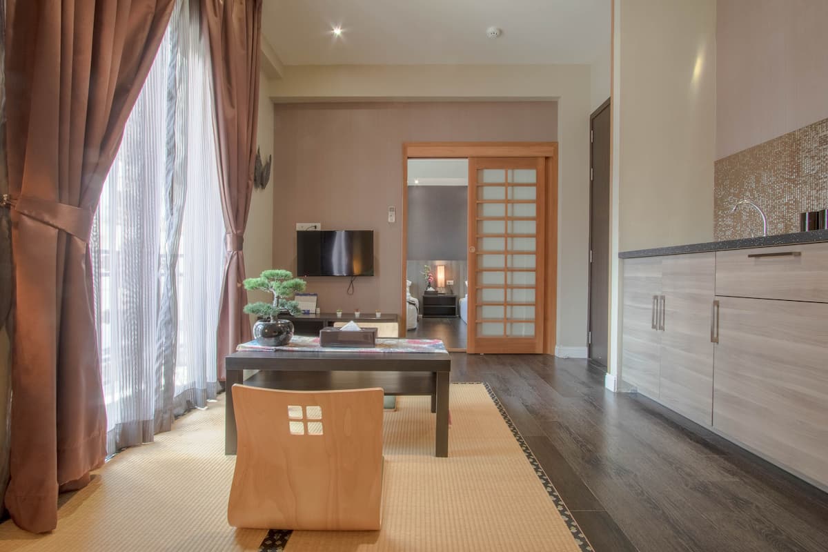 A modern living room with a dining table, a sofa, and a TV.