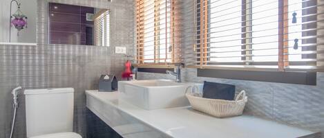 A modern bathroom with a toilet, sink, and shower.