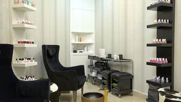 Relax in a comfortable seating area with two armchairs and a small table, surrounded by shelves for personal items and a mobile storage cart.