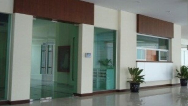 A modern hotel lobby with glass doors, a reception desk, and potted plants. - Cosy Place Hatyai (Hat Yai)
