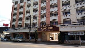 A multi-story hotel with a sign for 'Cosy Place' and a pharmacy across the street. - Cosy Place Hatyai (Hat Yai)