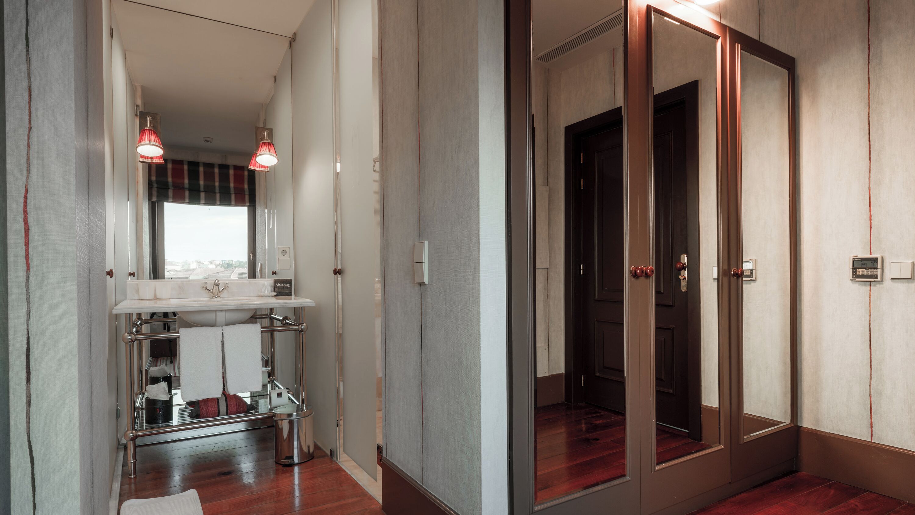 Un baño moderno con tocador, espejo y toallero.