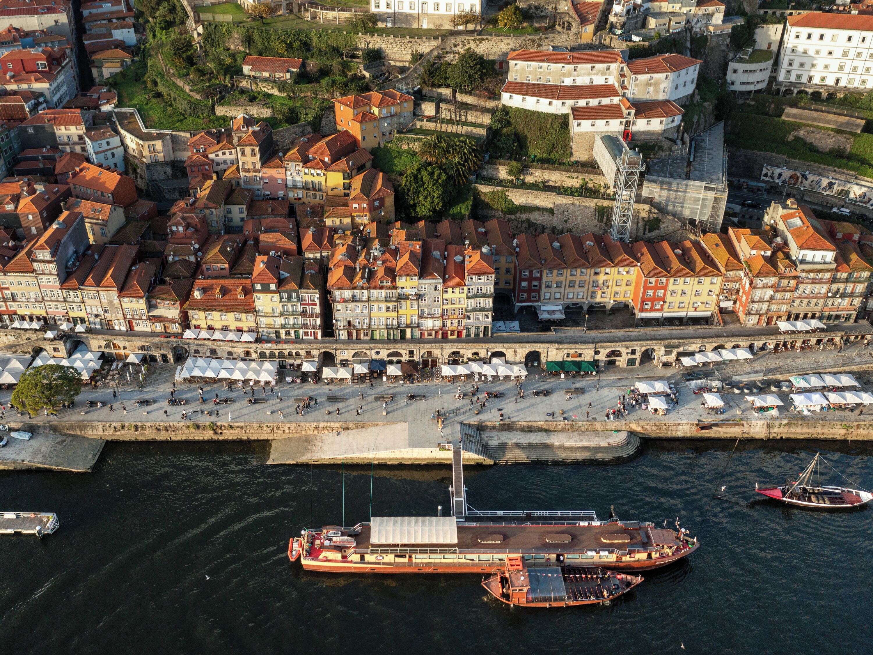Vista aérea de un pueblo ribereño con edificios históricos, un puente y un muelle para transbordador.