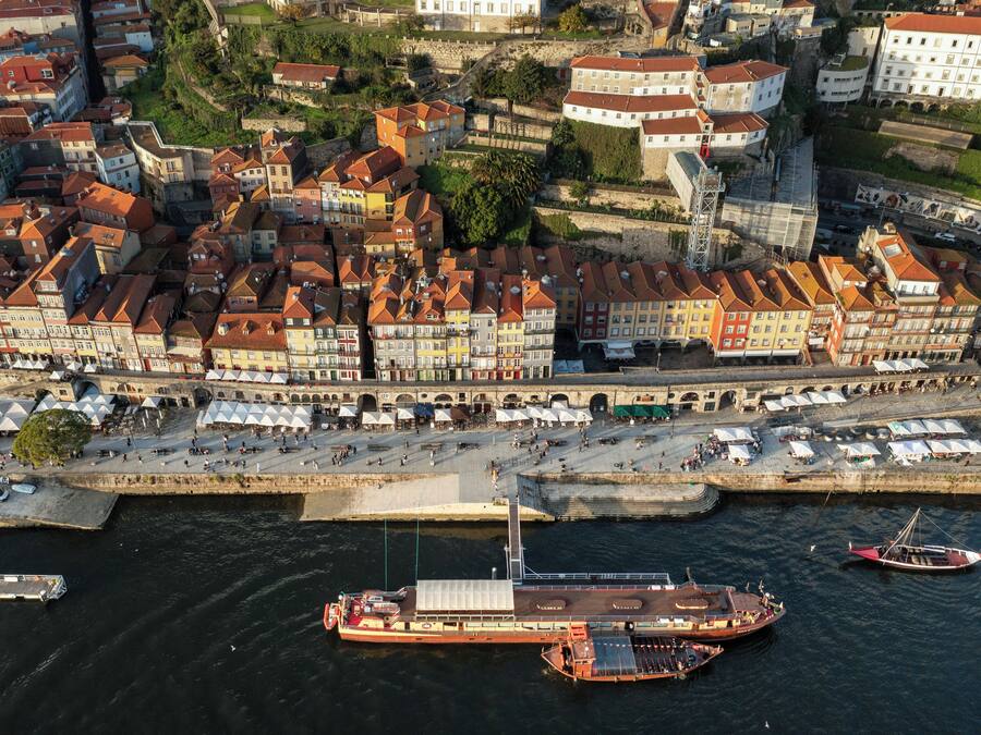 Vista aérea de un pueblo ribereño con edificios históricos, un puente y un muelle para transbordador.