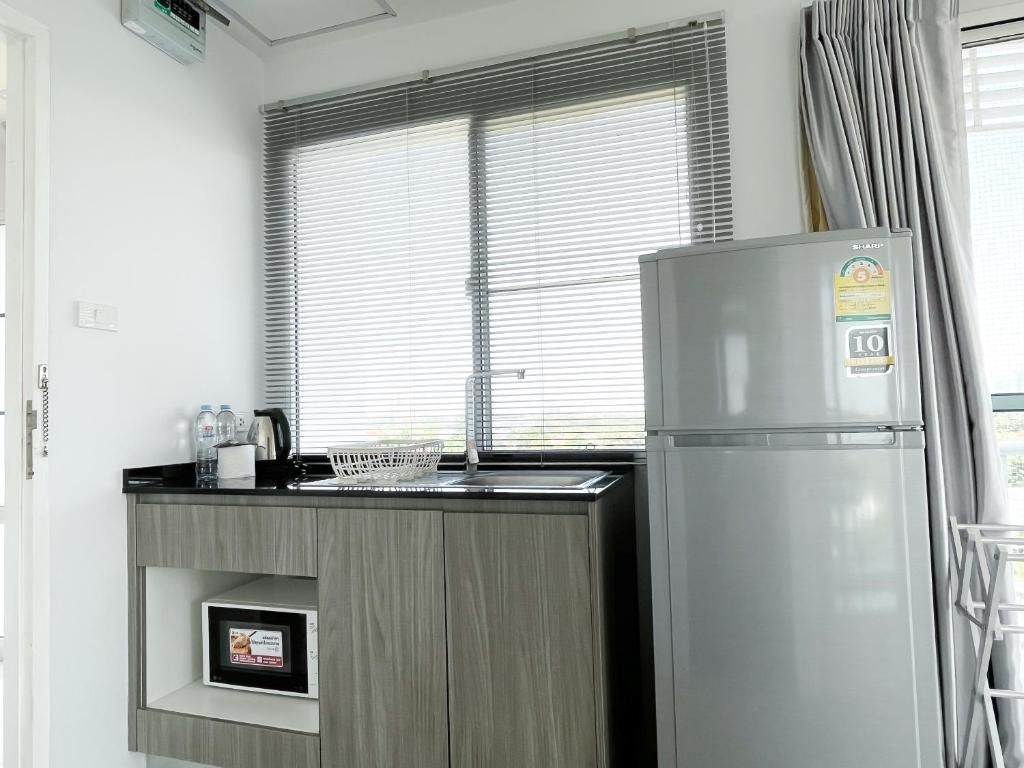 A compact kitchen with a built-in refrigerator, a microwave, and a sink.