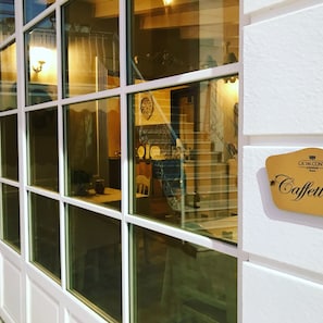 A window with reflections of a staircase and a clock.