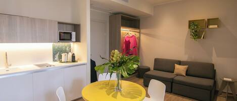 A modern living space with a kitchen, dining area, and a sofa.