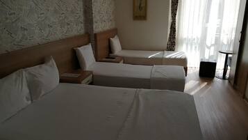 Ein Hotelzimmer mit zwei Betten, einem Holzkopfstück, einem kleinen Tisch und einem Bild an der Wand.