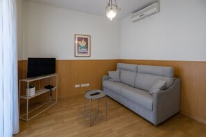 Apartamento, 1 habitación, vistas a la ciudad | Zona de estar | Una televisión de pantalla plana