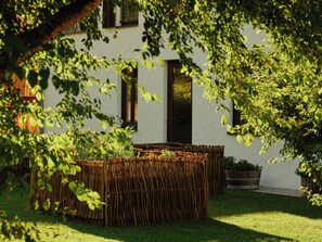 A modern building with a white exterior, a wooden fence, and a well-maintained garden. - Wiesergut (Saalbach-Hinterglemm)