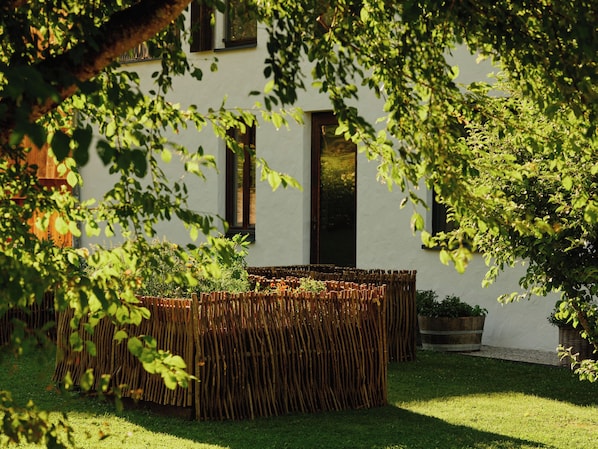 A modern building with a white exterior, a wooden fence, and a well-maintained garden. - Wiesergut (Saalbach-Hinterglemm)