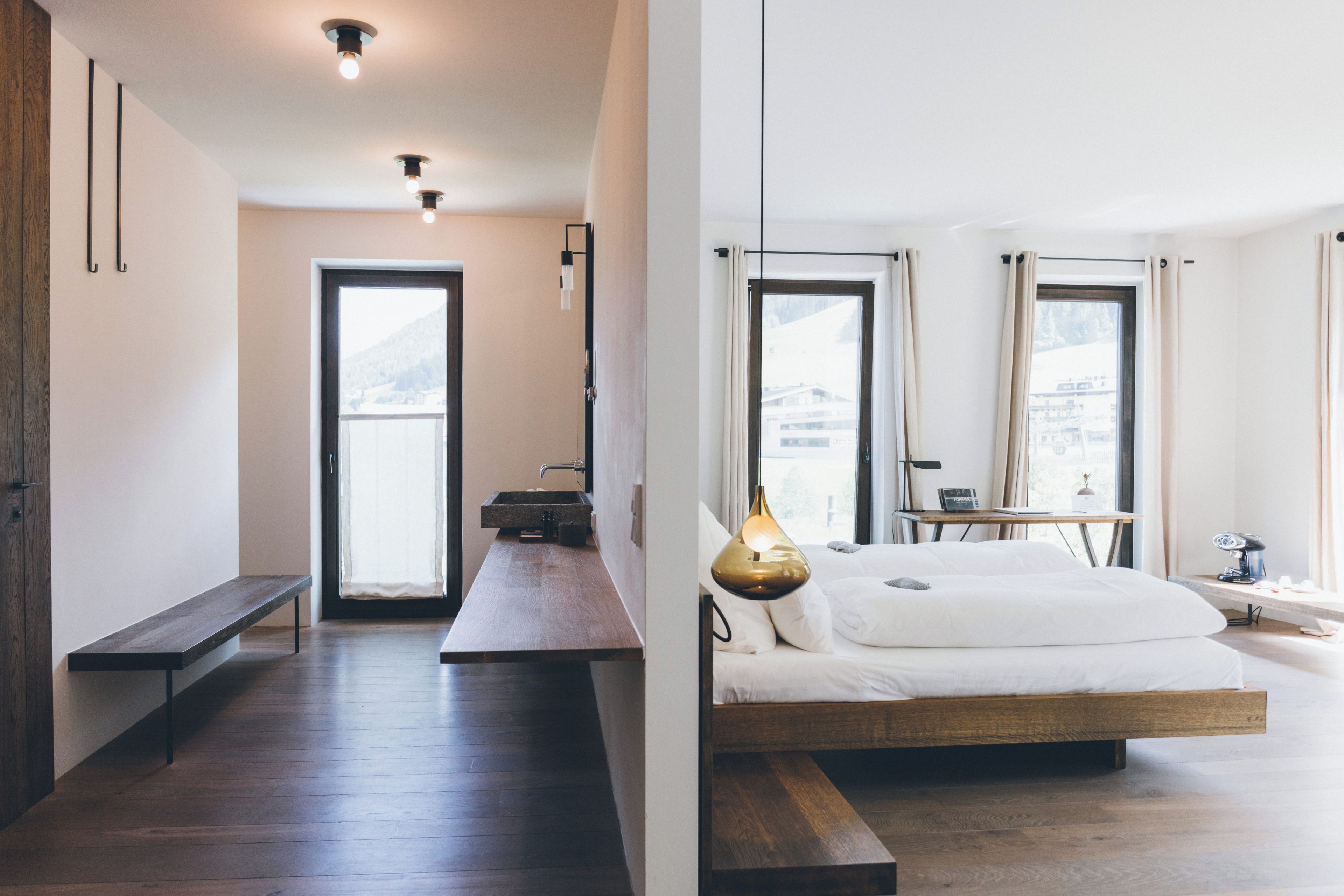 Un dormitorio moderno con una cama grande, mesita de noche y vistas al exterior.